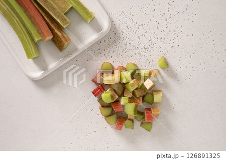 Freshly chopped green rhubarb on white background. Trendy organic food. Ready for cooking. Vegan concept. Close up. Freshly chopped green rhubarb on white background. Trendy organic food. Ready for cooking. Vegan concept. Close up. 126891325