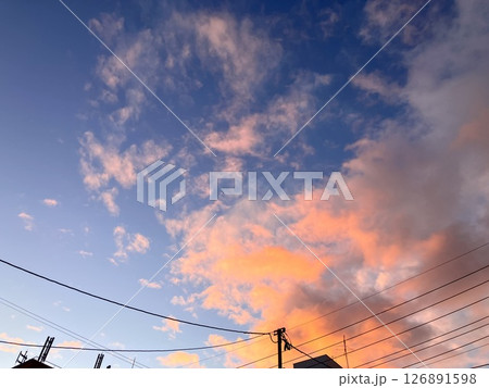 茜色の雲の多い空と電線 126891598