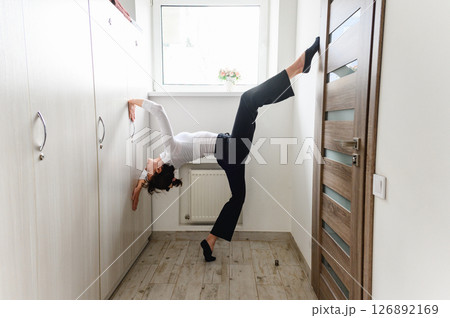 Woman performing a graceful stretching pose with dance elements. 126892169