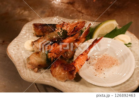 close up of grilled prawns wrapped with tofu skin on a plate with salt on the side close up of grilled prawns wrapped with tofu skin on a plate with salt on the side 126892463