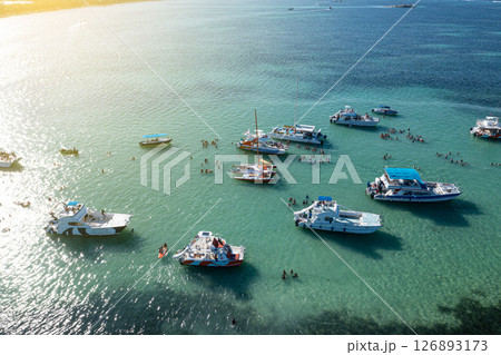 Boats with people having fun in caribbean sea near tropical island with palm trees. Travel destination. Aerial view Boats with people having fun in caribbean sea near tropical island with palm trees. Travel destination. Aerial view 126893173