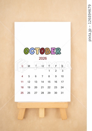 Calendar page for October 2026 with wood easel on old brown background. 126894679