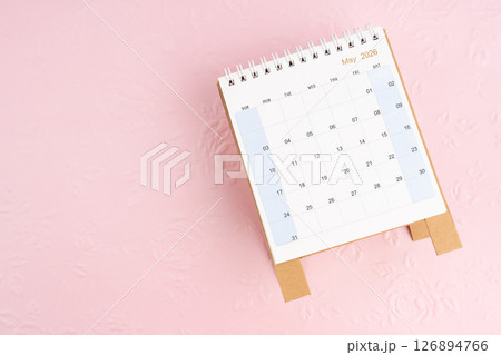 May 2026 desk calendar on pink paper with flower pattern background. May 2026 desk calendar on pink paper with flower pattern background. 126894766