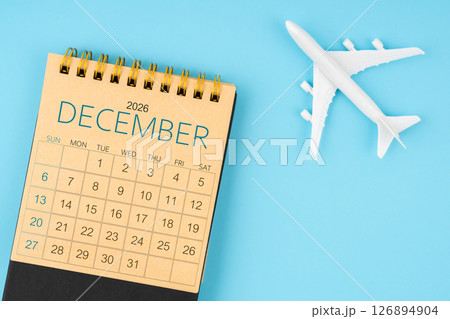 December 2026 calendar and airplane toy on blue background. December 2026 calendar and airplane toy on blue background. 126894904