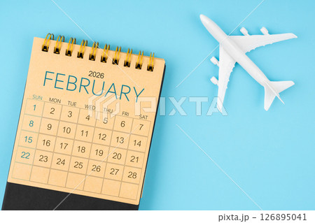 February 2026 calendar and airplane toy on blue background. 126895041
