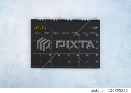 Blank calendar for January 2026, Black spiral desktop calendar on wooden background. Blank calendar for January 2026, Black spiral desktop calendar on wooden background. 126895250