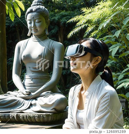 仏像の傍らでVRヘッドセットを付けて瞑想する女性 126895289