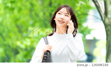 スマートフォンで話す笑顔の女性・ビジネスウーマン スマートフォンで話す笑顔の女性・ビジネスウーマン 126896189