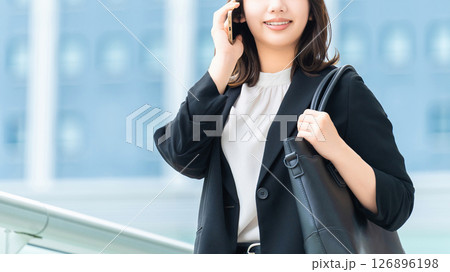 スマートフォンで話す笑顔の女性・ビジネスウーマン スマートフォンで話す笑顔の女性・ビジネスウーマン 126896198
