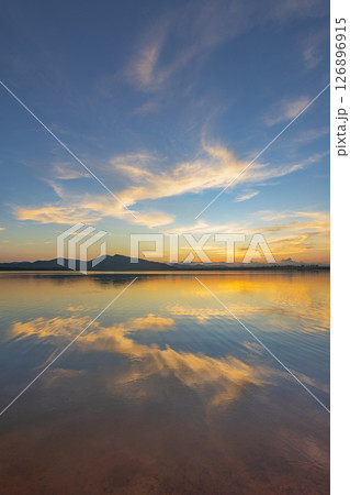 Landscape of mountains and lake at sunset and clouds reflected in the water. Landscape of mountains and lake at sunset and clouds reflected in the water. 126896915