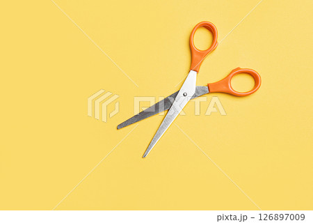Open scissors on yellow background Open scissors on yellow background 126897009