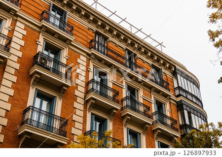 Charming residential building in Madrid featuring classic balconies and elegant architecture. Charming residential building in Madrid featuring classic balconies and elegant architecture. 126897933