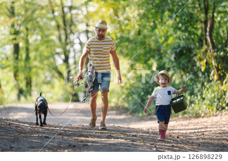 A mature father with a small toddler son and a dog going fishing. 126898229