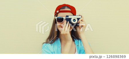 Portrait of happy young woman photographer with film camera, modern girl taking a picture 126898369