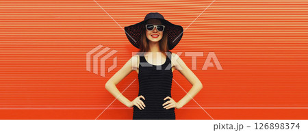 Summer portrait of beautiful stylish young woman posing in hat, glasses on bright red background 126898374