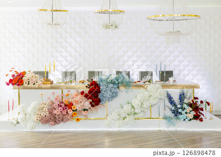 Wedding table decorated with colorful flowers and candles Wedding table decorated with colorful flowers and candles 126898478