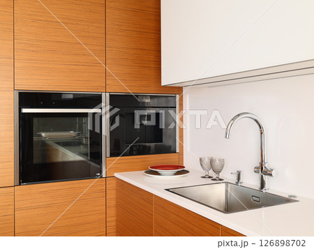 A Modern Kitchen Featuring a Sleek Design with Stylish Appliances and Attractive Features 126898702