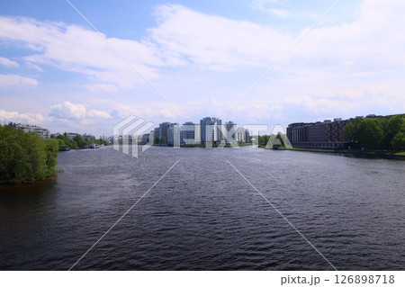 Enjoy the stunning river view with modern buildings and vibrant greenery, blending urban and nature 126898718