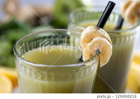 Green smoothie with spinach,banana, apple, and lemon on white marble Green smoothie with spinach,banana, apple, and lemon on white marble 126898818