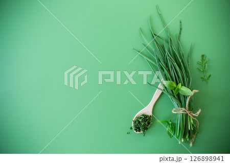 Dried and fresh green onions on green background from above 126898941