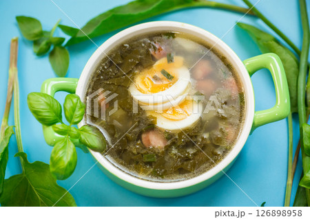 Appetizing spring sorrel borscht isolated on a blue background Appetizing spring sorrel borscht isolated on a blue background 126898958