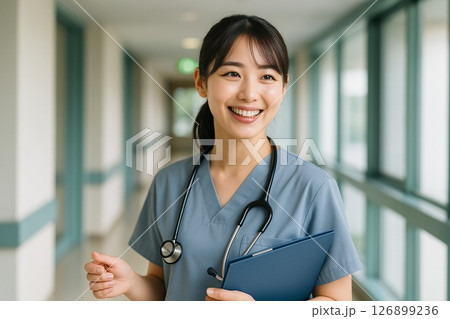 診察を終えて笑顔で話す若い女性看護師（病院内・ナース服・聴診器・日本人） 126899236
