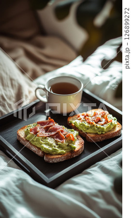 Savor the morning with colorful toasts topped with fresh ingredients and crispy bacon, paired with a warm cup of coffee, all set on a bed tray in a tranquil space Savor the morning with colorful toasts topped with fresh ingredients and crispy bacon, paired with a warm cup of coffee, all set on a bed tray in a tranquil space 126899272