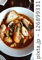 Traditional bouillabaisse seafood stew served in a rustic bowl with fresh herbs and crusty bread at a cozy French restaurant 126899331