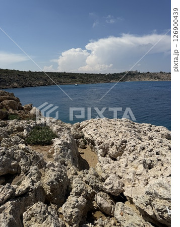 Picturesque beach, waves crashing on the sandy shore. Sea waves beat against the rocks. Cyprus Island, Mediterranean Sea. 126900439