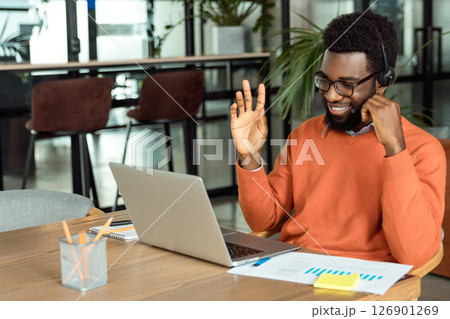 Dark-skinned businessman having a call online and looking involved 126901269
