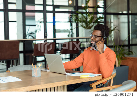 Dark-skinned businessman having a call online and looking involved 126901271