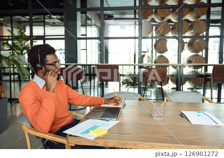 Dark-skinned businessman having a call online and looking involved 126901272