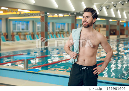 Confident caucasian athletic man with a towel in the swimming pool Confident caucasian athletic man with a towel in the swimming pool 126901603