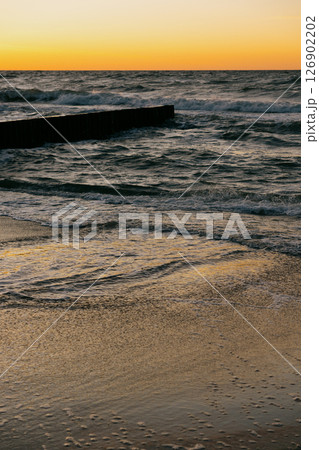 Ocean with waves, sunset sky is orange. water is choppy and waves are crashing on shore. Ocean with waves, sunset sky is orange. water is choppy and waves are crashing on shore. 126902202