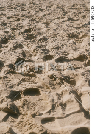 chain of footprints in the sand. The footprints of human shoes are arranged in row and very close. 126902206