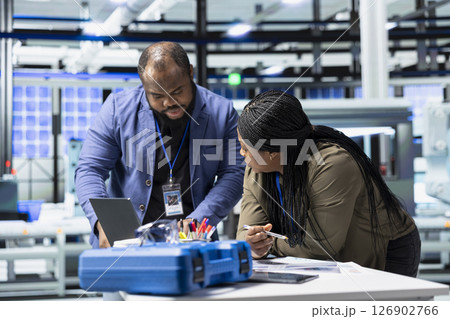 Black industry engineers team working together on solar panel systems during a production inspection, ensuring engineering accuracy, quality control and factory operations efficiency. Black industry engineers team working together on solar panel systems during a production inspection, ensuring engineering accuracy, quality control and factory operations efficiency. 126902766