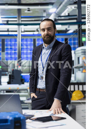 Manufacturing analyst reviewing solar panel production workflow, focusing on technological precision and sustainable power development in a high tech industrial environment. Manufacturing analyst reviewing solar panel production workflow, focusing on technological precision and sustainable power development in a high tech industrial environment. 126902772