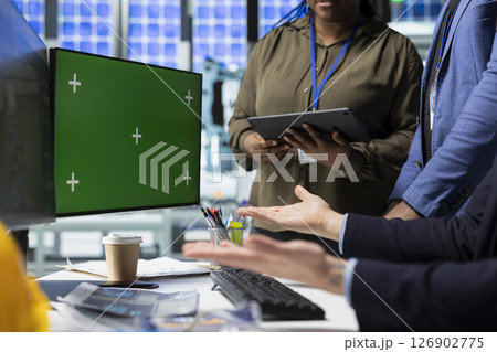 Coworkers brainstorming solutions with mockup display in solar plant, advancing industrial goals through collaboration and corporate responsibility. Team of engineers share insight. 126902775