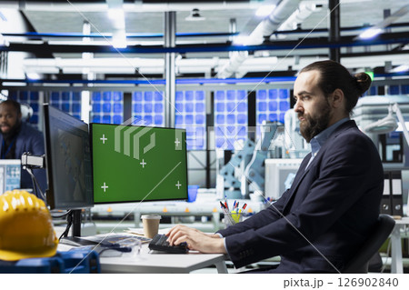 Male innovation consultant explores engineering upgrades with mockup in a solar panel facility, sustainable energy improvements and modern manufacturing processes for development. Male innovation consultant explores engineering upgrades with mockup in a solar panel facility, sustainable energy improvements and modern manufacturing processes for development. 126902840