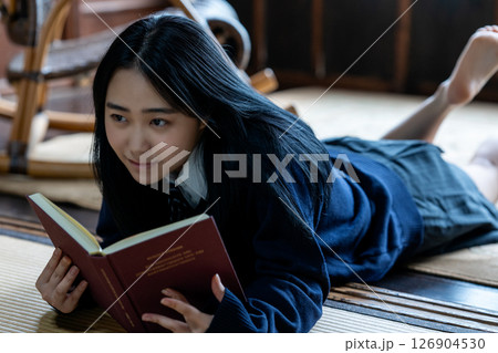 寝転んで本を読む女子高生 126904530