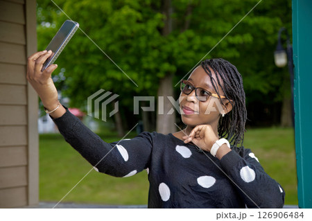 Smiling African American Woman Taking Selfie with Smartphone in Park 126906484