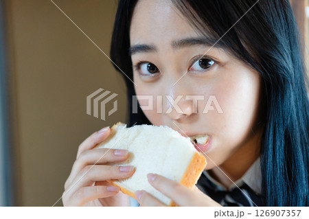 食パンを食べる女子高生 126907357