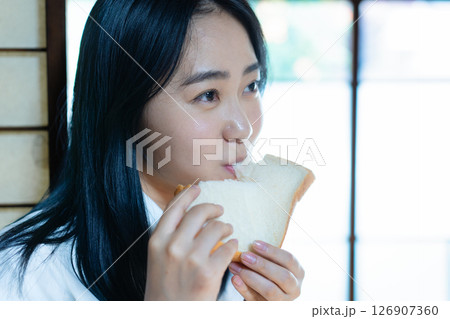 食パンを食べる女子高生 126907360