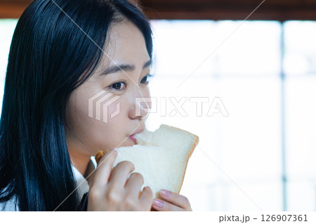 食パンを食べる女子高生 126907361