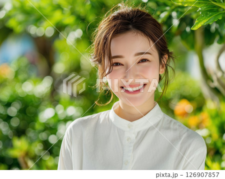 緑あふれる屋外で微笑む女性の明るい人物写真 126907857