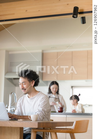 自宅でリモートワークをする男性と家族 126907962