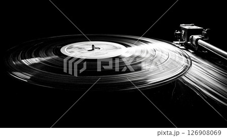 Black and white vinyl record on turntable with grooves and tonearm 126908069
