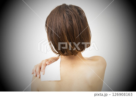 肩に湿布を貼った女性の後ろ姿 肩に湿布を貼った女性の後ろ姿 126908163