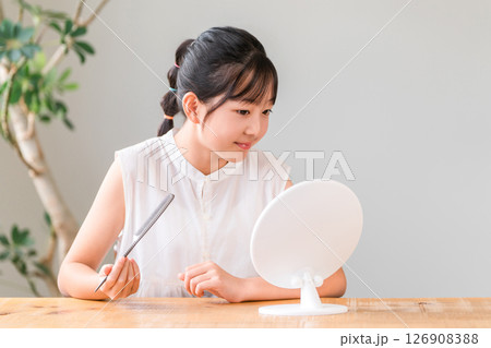 鏡を見ながらヘアセットする子供,女の子,小学生,中学生 鏡を見ながらヘアセットする子供,女の子,小学生,中学生 126908388