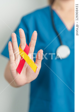 World hepatitis day awareness month, 28 July. Doctor holding Red and Yellow ribbon. Liver cancer, Jaundice, Cirrhosis, Failure, Enlarged, Hepatic Encephalopathy and Health concept 126908431